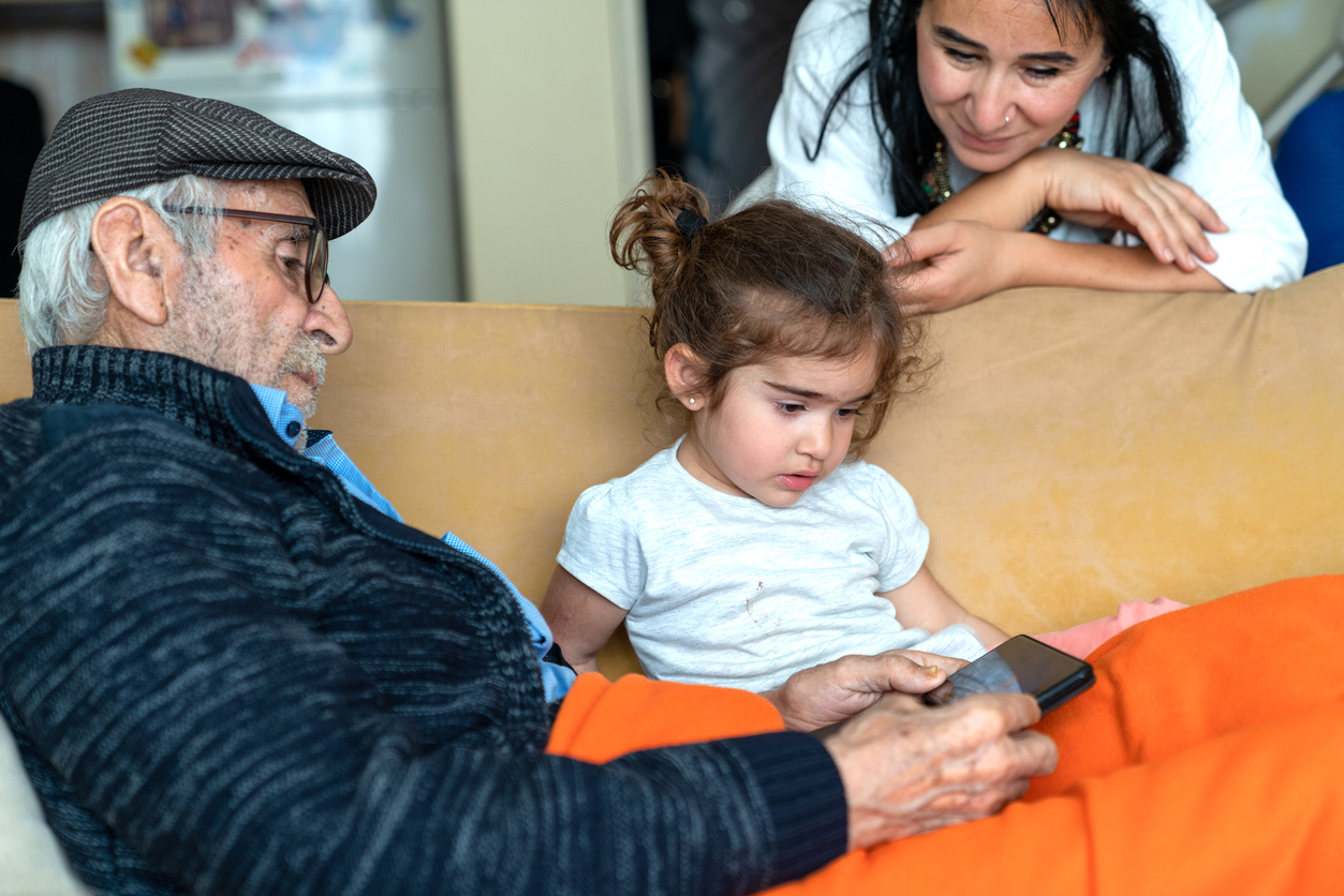Grandfather And Granddaughter Using Smartphone