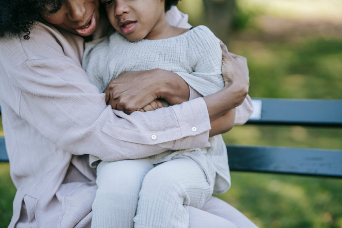 Woman hugging young child in the park